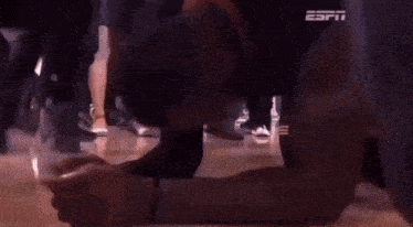 a man is kneeling on the floor with his head on his knees in front of an espn logo .