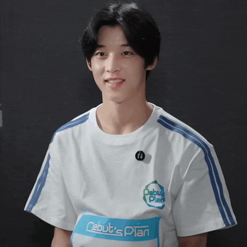 a boy wearing a white shirt with the words debut 's plan on it