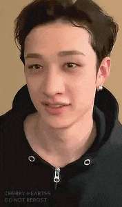 a close up of a person 's face wearing a black hoodie and earrings .