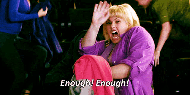 a woman in a purple shirt is holding a pink shirt and screaming enough enough .