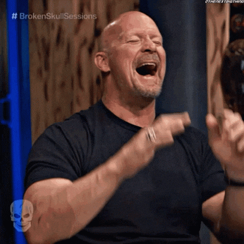 a man is laughing with his mouth open and his hands in the air