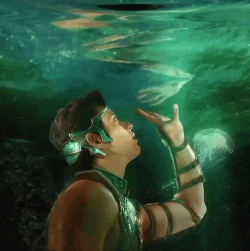 a man is looking up at a jellyfish in the ocean