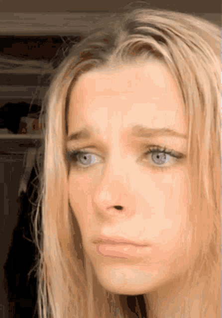 a close up of a woman 's face with blue eyes and blonde hair