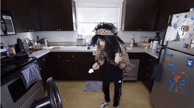 a person in a leopard print shirt is standing in a kitchen