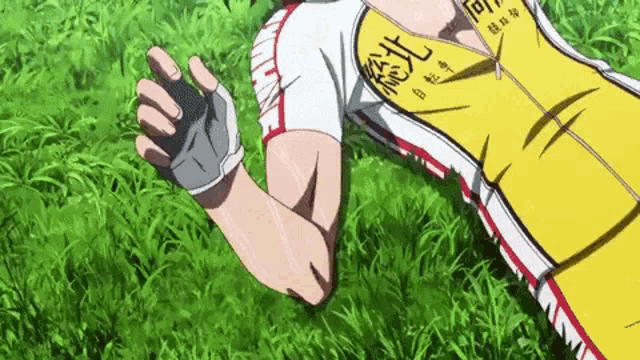 a man in a yellow shirt is laying on the grass