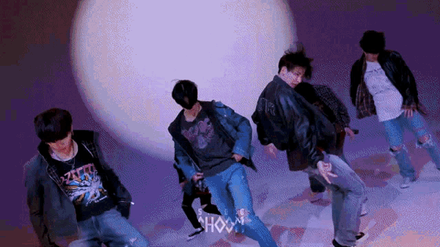 a group of young men are dancing in front of a purple background with the word show on it .
