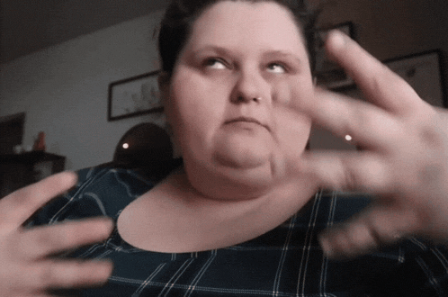 a woman in a plaid shirt is making a funny face with her hands