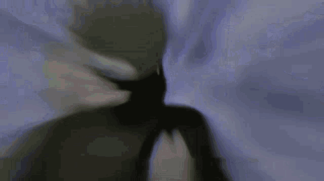 a close up of a person standing in front of a blue wall .