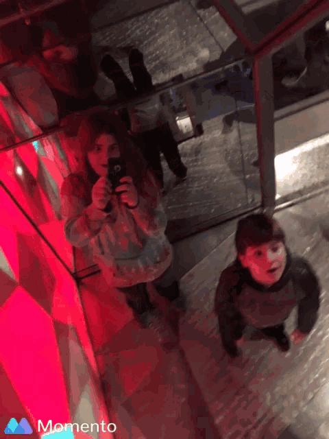 a girl taking a picture of herself with a momento icon