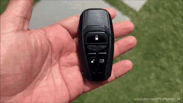 a person is holding a car key with youtube.com/namastecar written on the bottom