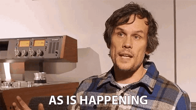 a man wearing a plaid shirt says as is happening