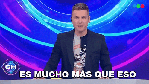 a man in a suit stands in front of a purple background with the words es mucho mas que eso below him