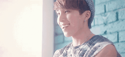 a close up of a young man wearing a hat and smiling .