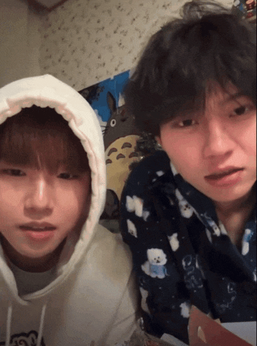 a boy wearing a white hoodie has the letter n on his shirt