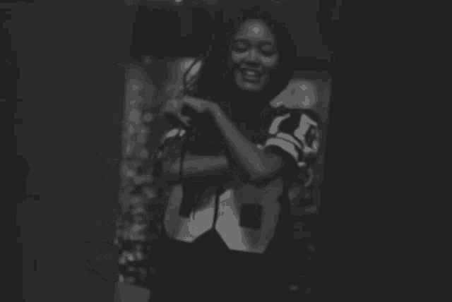 a black and white photo of a woman wearing a jersey with the number 80 on it
