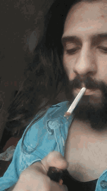 a man with a beard is smoking a cigarette