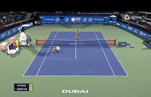 a tennis game is being played on a court sponsored by dubai