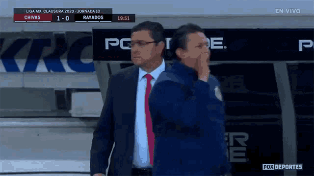 two men standing in front of a sign that says ' fox deportes ' on it
