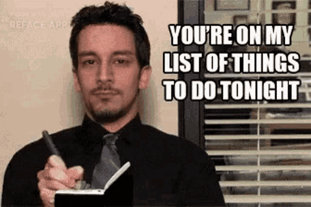 a man in a suit and tie is holding a pen and a notebook .