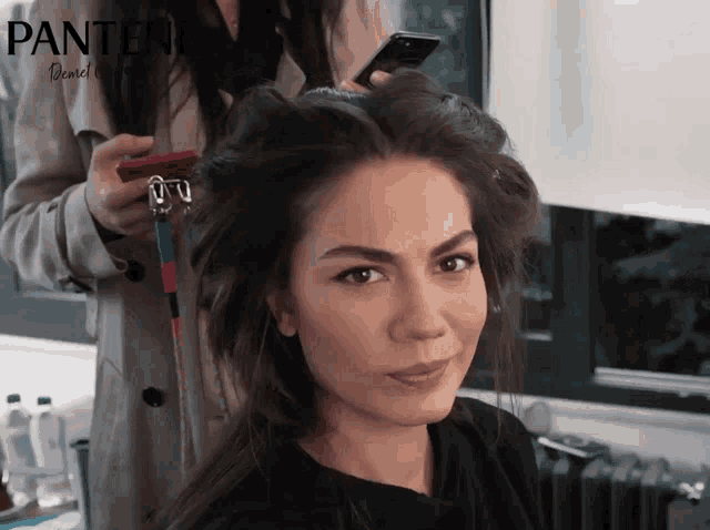 a woman getting her hair done by a pantene stylist