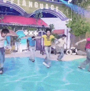 a group of people are dancing in a pool in front of a building that says language .