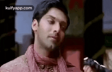 a man is holding a gun in his hand and making a face .