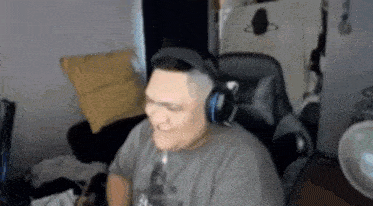 a man wearing headphones is sitting in a chair in front of a computer .