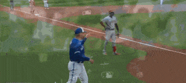 a baseball player in a blue jays uniform talks to a referee