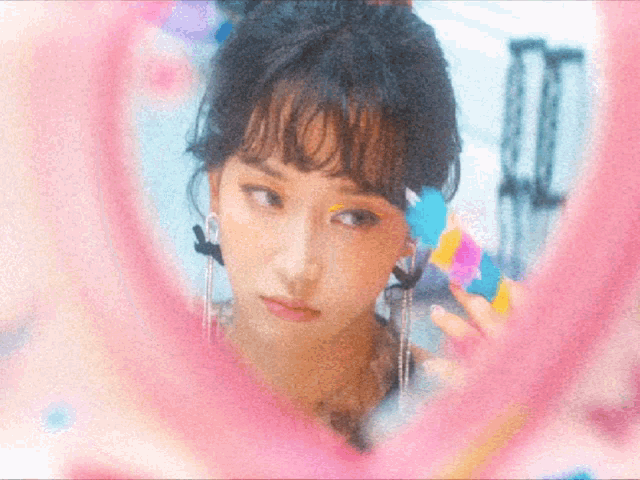 a woman looking at herself in a mirror with a pink circle around her