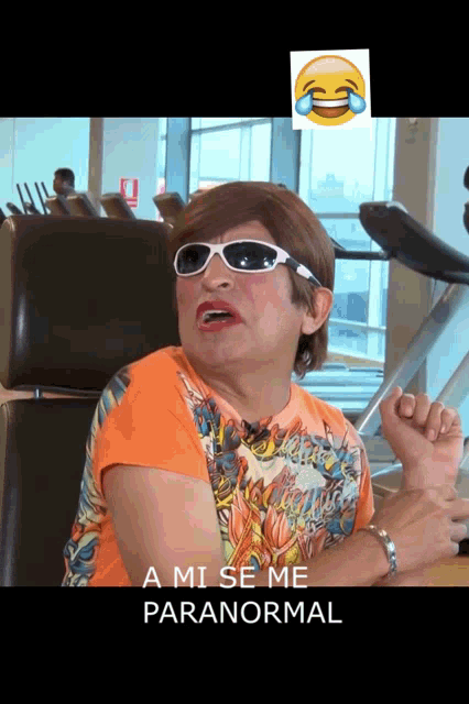 a woman wearing sunglasses and an orange shirt says " a mi se me paranormal "