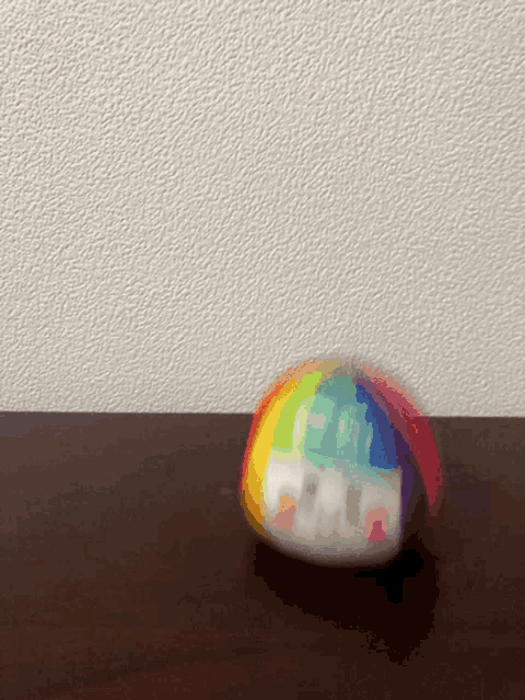 a rainbow colored ball is sitting on a table