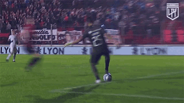 a man kicking a soccer ball in front of a banner that says lyon