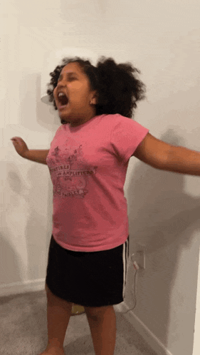 a little girl wearing a pink shirt that says " amplified " on it