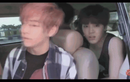 a group of young men are sitting in the back of a car .