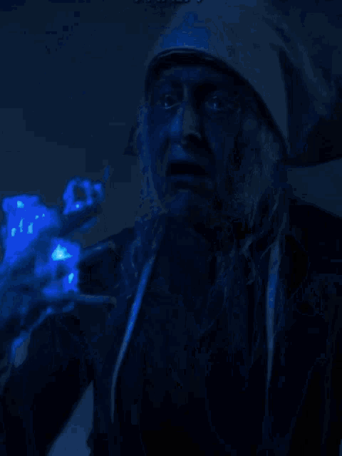 two people are standing in a dark cave with blue lights
