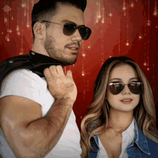 a man and a woman wearing sunglasses are standing next to each other in front of a red background