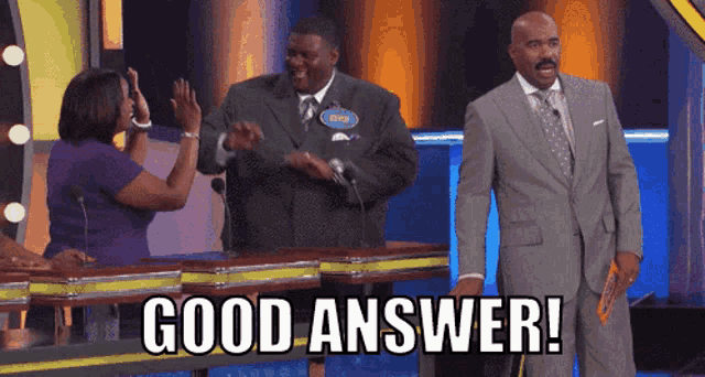 a man in a suit says good answer while standing in front of a group of people