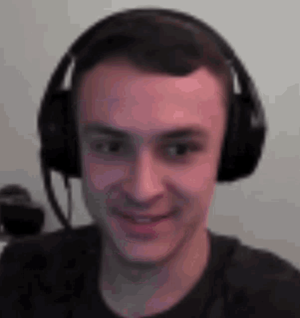 a young man is wearing headphones and smiling .