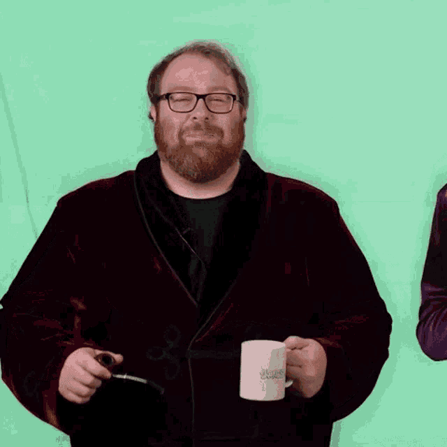 a man with a beard and glasses is holding a mug that says harry potter on it