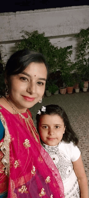 a woman is posing for a picture with a little girl
