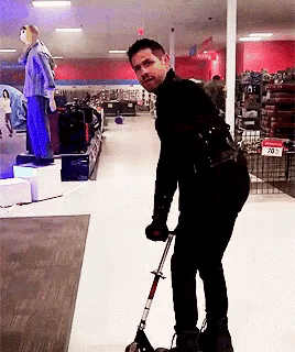 a man rides a scooter in a store with a sign that says 20