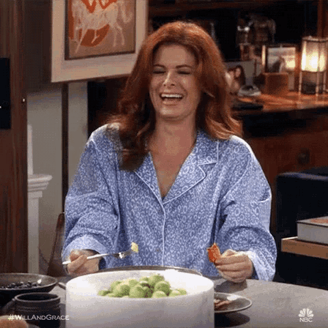 a woman in pajamas is sitting at a table eating a plate of food .