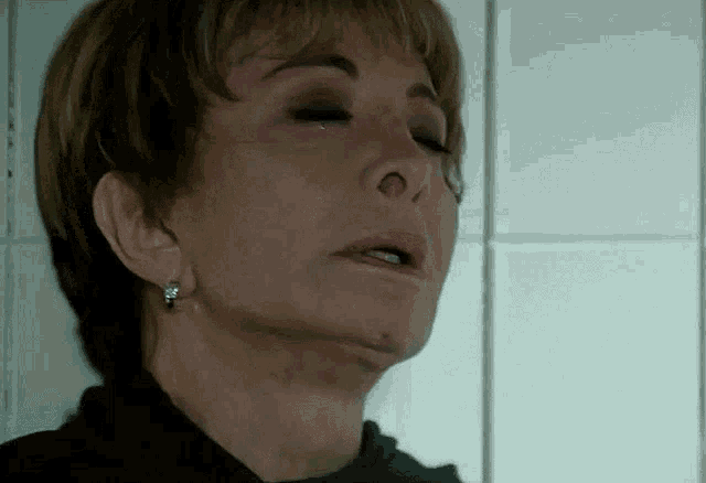 a close up of a woman 's face with tears coming out of her eyes