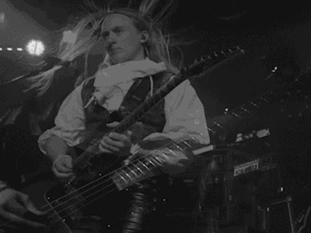 a black and white photo of a woman playing a guitar
