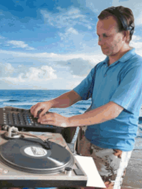 a man in a blue shirt is playing a record