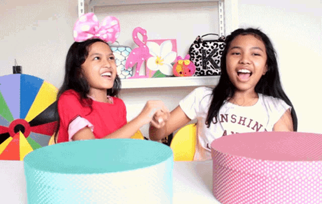 a girl wearing a shirt that says sunshine on it holds hands with another girl
