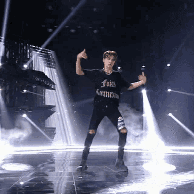 a man in a black shirt that says faith connexion is dancing on a stage