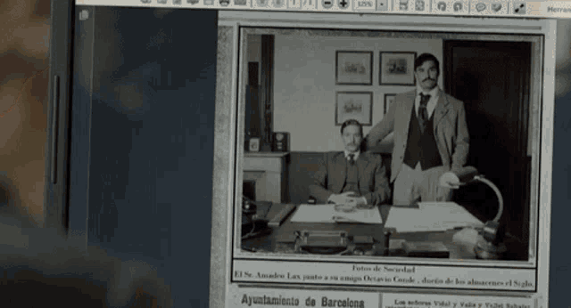 a black and white photo of two men standing next to each other on a computer screen