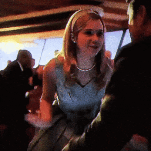 a woman in a white dress is dancing with a man in a black suit