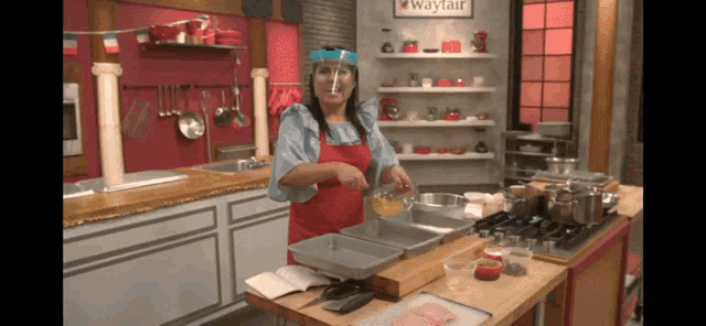 a woman wearing a face shield is preparing food in a kitchen